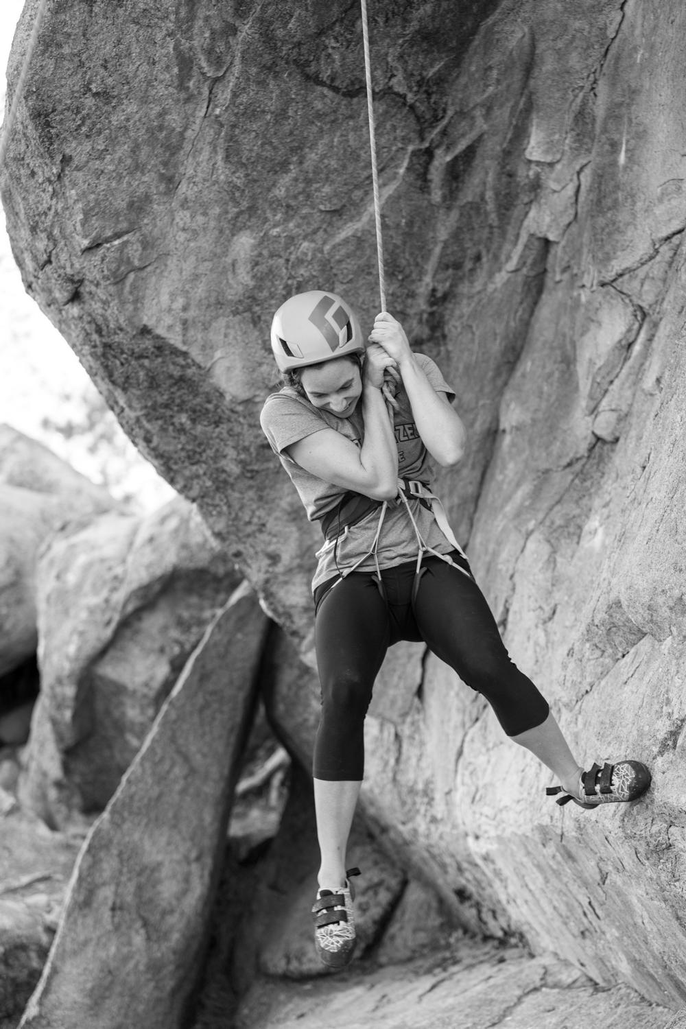 Lady practising rock climbing with helmet and harness